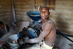 Homme Tamberma et moulin à céréales